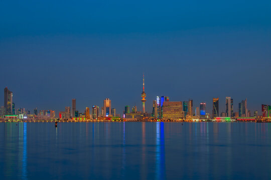 Kuwait City Skyline at Blue Hour Reflected in the Arabian Gulf Waters at Dusk. Kuwait City skyline view.