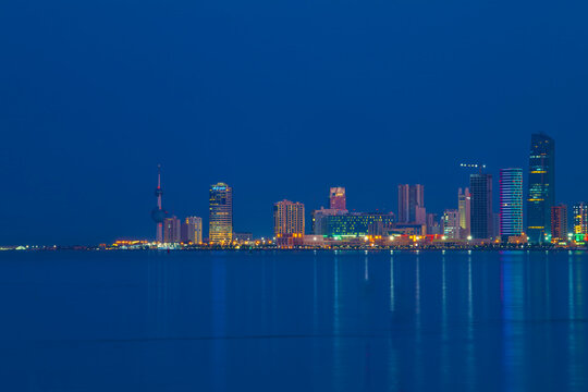 Kuwait City Skyline at Blue Hour Reflected in the Arabian Gulf Waters at Dusk. Kuwait City skyline view.
