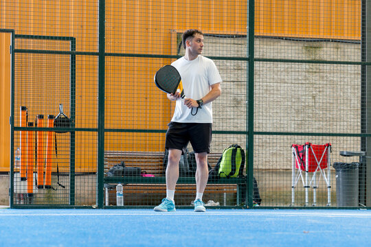 Padel player waiting to serve during doubles match