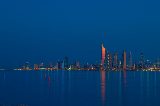 Kuwait City Skyline at Blue Hour Reflected in the Arabian Gulf Waters at Dusk. Kuwait City skyline view.
