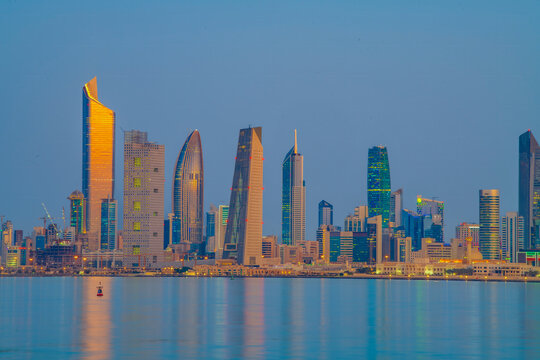 Kuwait City Skyline at Blue Hour Reflected in the Arabian Gulf Waters at Dusk. Kuwait City skyline view.