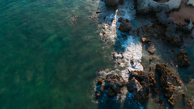 Rocky coastline waves crashing against rocks, in ocean and rocky shoreline, with rocks, waves, with rock, water texture, from a aerial view perspective, with blue-green, Praia dos Aveiros Portugal