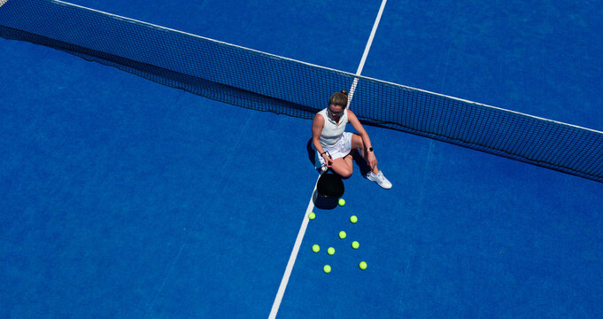 Aerial view of a vibrant padel court with dynamic shadows on a sunny afternoon