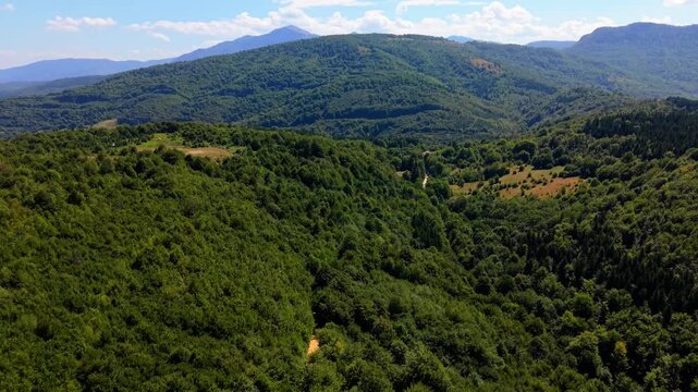 Aerial Drone Flyover of Forest Towards Green Mountain Hills on Ivan Sedlo