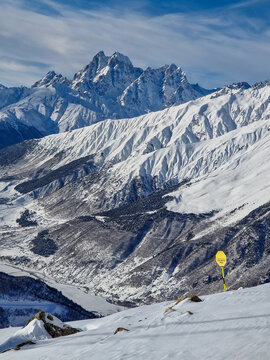 Snow-covered mountain range with winter trail signal
