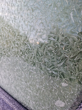 Frost crystal pattern on frozen window glass surface