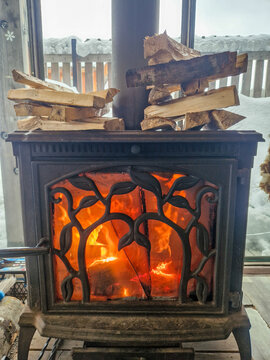 Wood-burning stove with firewood in snowy winter cabin