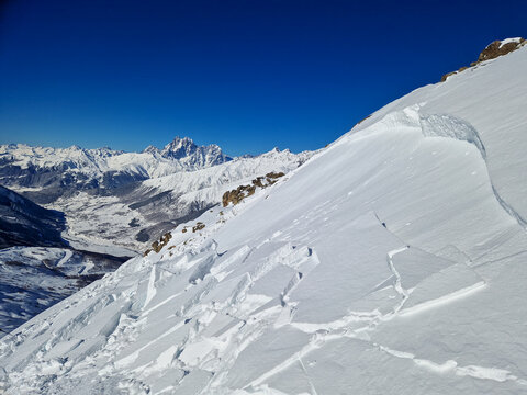 Snowy alpine ridge above a mountain valley in winter