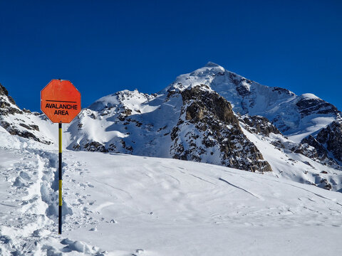 Avalanche warning sign in snowy alpine mountain landscape
