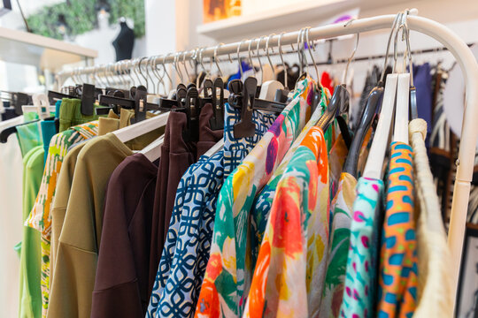 Colorful clothes on rack in fashion shop interior