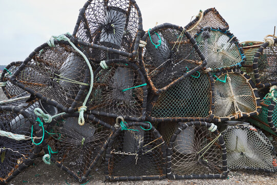 Stack of fishing traps and nets on a coastal shore