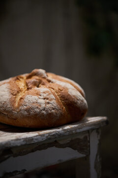 Rustic artisan bread loaf on weathered bakery table