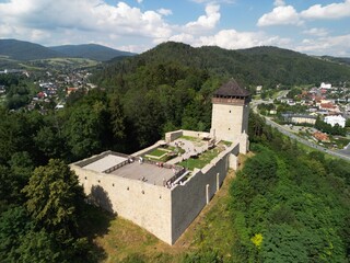 Muszyna - Polska Pięknie położone miasto w górach Beskidach zdjęcia wykonane dronem z powietrza. Zamek na wzgórzu, las, niebo, chmury, miasteczko, dolina, rzeka, lato, wiosna. © Konrad