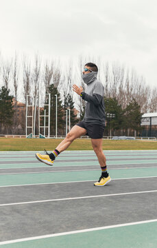 Male runner warm up on outdoor athletics track