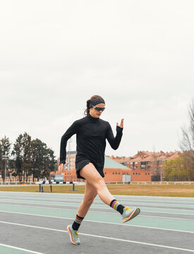Female runner perform leg stretch on outdoor track