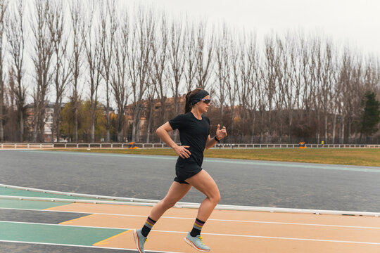 Female runner sprinting on outdoor athletics track