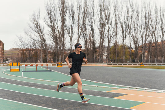 Female athlete run on outdoor track in urban park