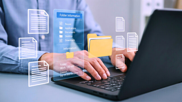 Professional managing digital documents on a laptop, interacting with a virtual interface displaying files and folders. Cloud storage and business technology