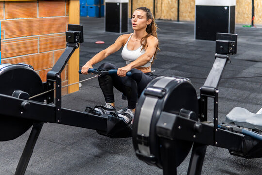 Woman exercise on rowing machine in modern gym