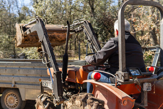 Man operating tractor loader for countryside field work