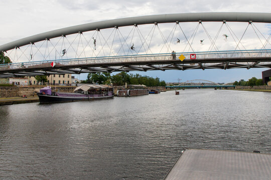 Balancing acrobatic sculptures suspended above the Vistula River on Father Bernatek Footbridge. Created by Polish sculptor Jerzy Kędziora. Suspended across the bridge. Krakow, Poland, June 9, 2026. 