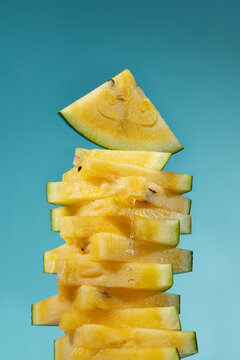 Yellow watermelon slice stack with honey on blue background