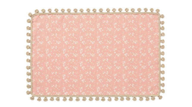 Peach pink floral placemat with tiny white daisy print and beige pom pom trim isolated on white background