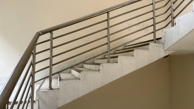 Looking up a concrete stairwell with a modern metal railing