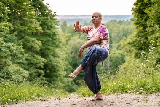 Mature man practice tai chi for healthy aging outdoors