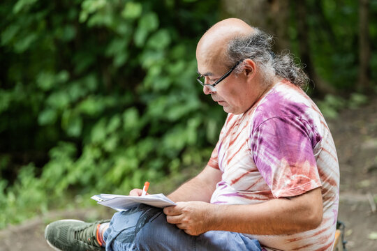 Mature man journaling outdoors for wellness and healthy aging
