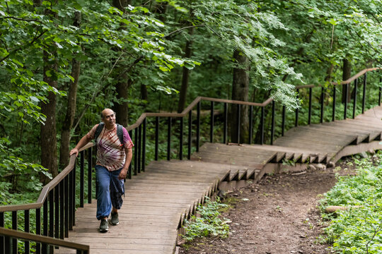 Mature man hiking on forest boardwalk for healthy aging