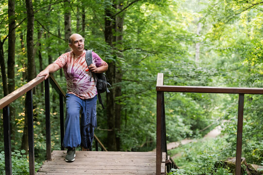 Mature man hiking on forest bridge for healthy aging