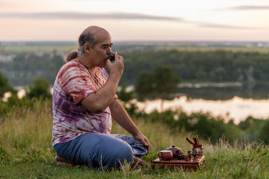 Man enjoying tea ritual outdoors at sunset