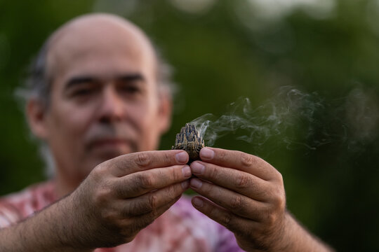Mature man practice holistic wellness with sage outdoors