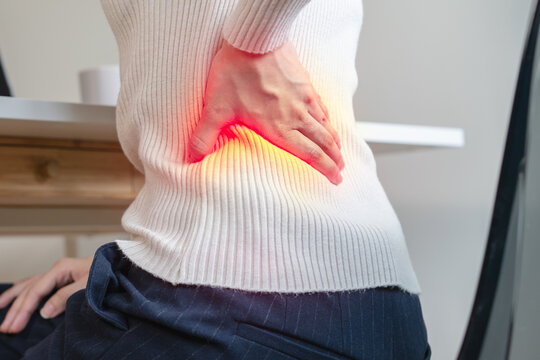 office syndrome, woman with back pain symptoms during work in the office.