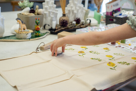 small child stamps a print on fabric with paints