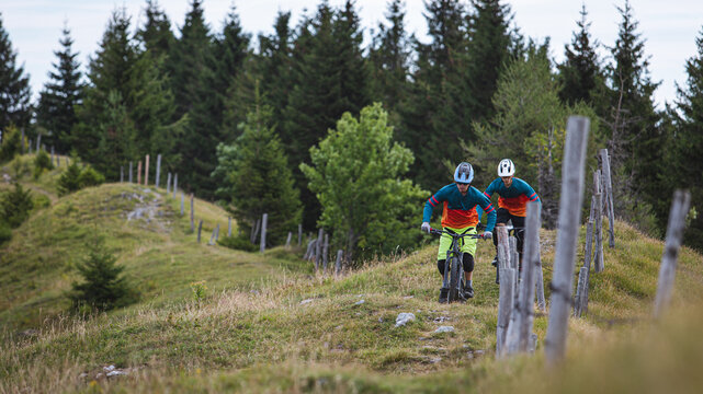 Mountain bikers riding across an alpine meadow in the Austrian Alps