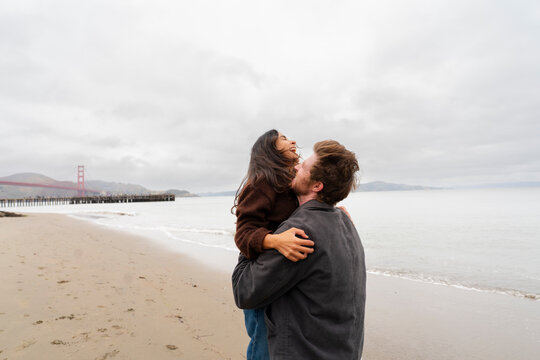couple date woman jumping into mans arms 