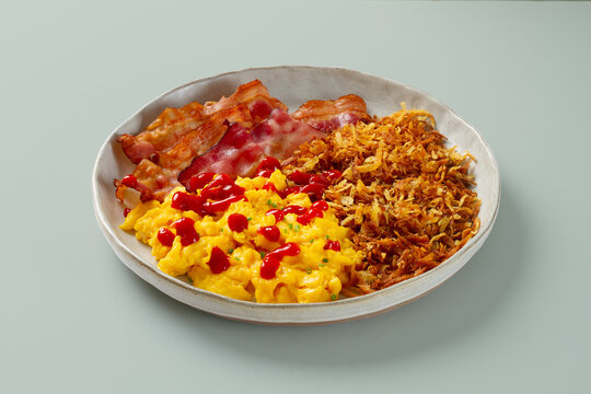 Breakfast plate with bacon hash brown scrambled eggs ketchup