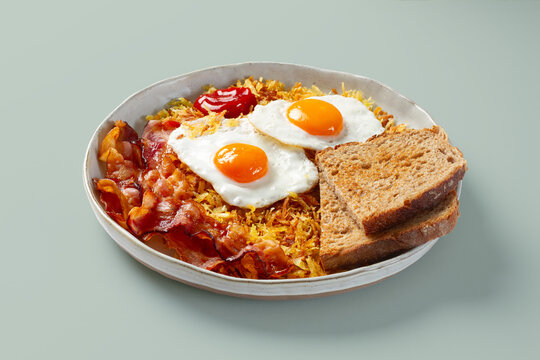 Hearty breakfast plate with bacon eggs hash brown and toast