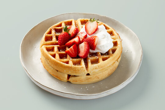Belgian waffle with strawberry and whipped cream topping