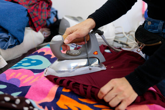 Woman using iron on garment