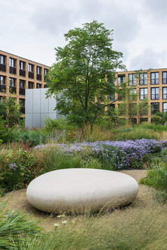 Urban garden courtyard at the Meelfabriek in Leiden with modern brick apartments and lush greenery