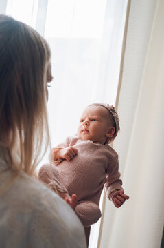 Mother holding newborn baby during first days at home