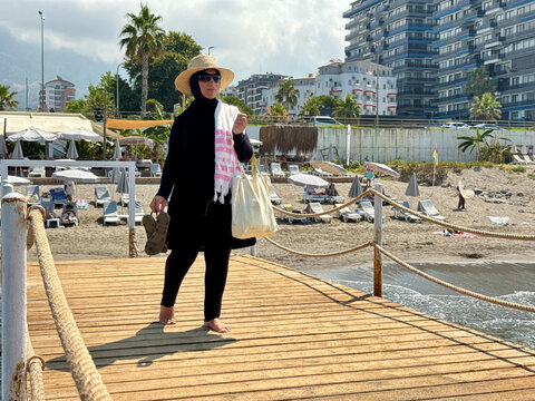 Woman Walking Along Wooden Boardwalk