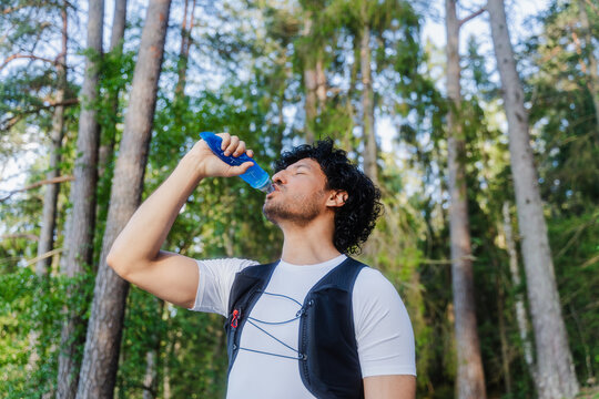 Athlete Hydrating In Pine Forest
