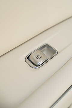 Electric car window control button on beige door panel