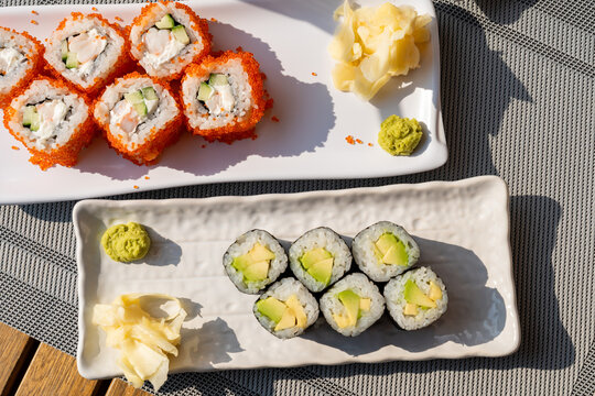 Assorted sushi rolls with salmon roe on white platter