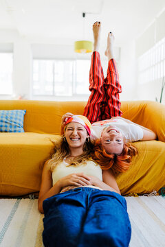 Happy friends enjoying playful upside down moment at home