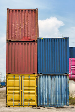Stacked colorful cargo shipping containers in freight terminal yard